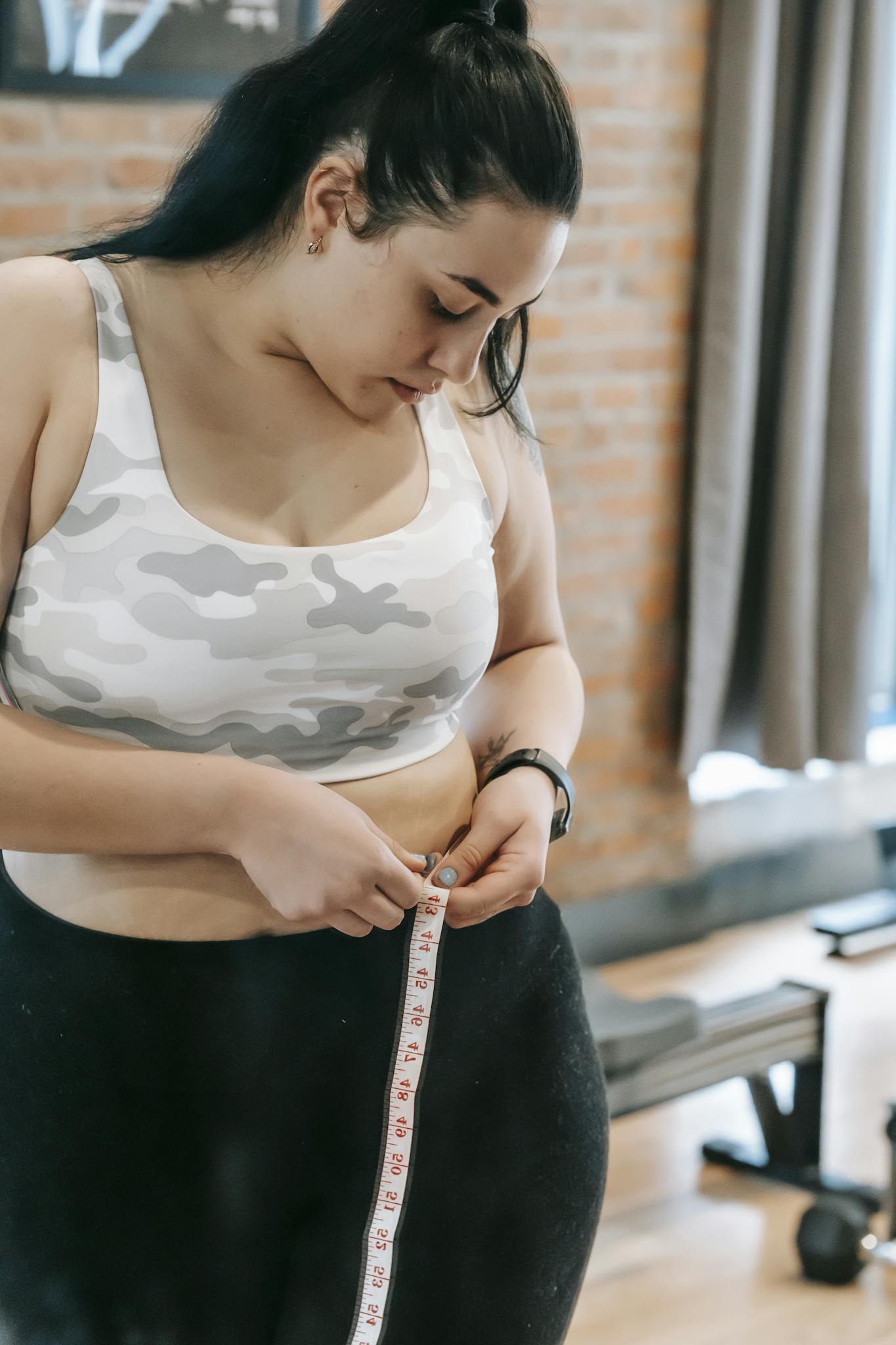 Young Obese Female Using Tape For Evaluating