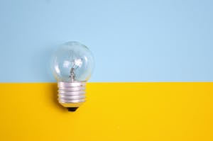 Easy Keto Recipes for Beginners: What the Keto Diet Is and How It Works A clear light bulb against a vibrant blue and yellow background, symbolizing energy and creativity.