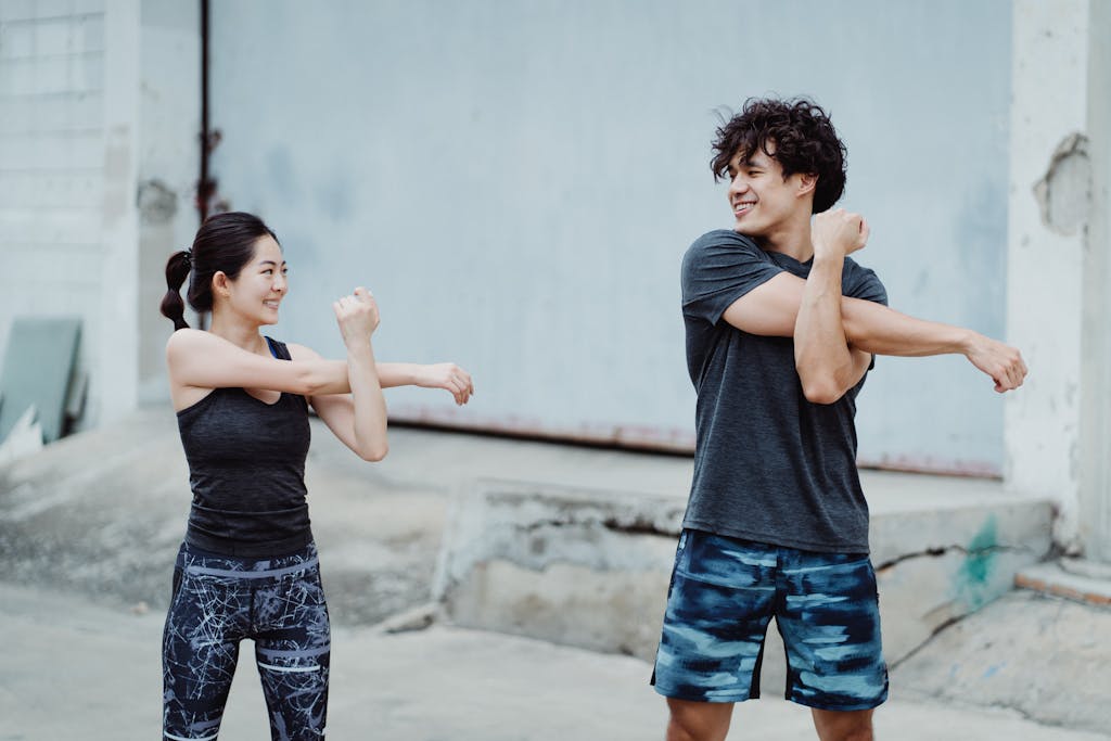 Hi there! Welcome to your Wellness journey. Couple engaging in a warm-up stretch outdoors. Emphasizes health and fitness.
