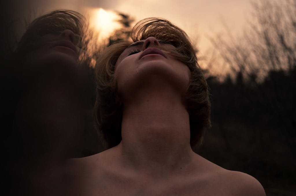 Hi there! Welcome to your Wellness journey. Moody portrait of a woman in nature reflecting emotion at dusk.