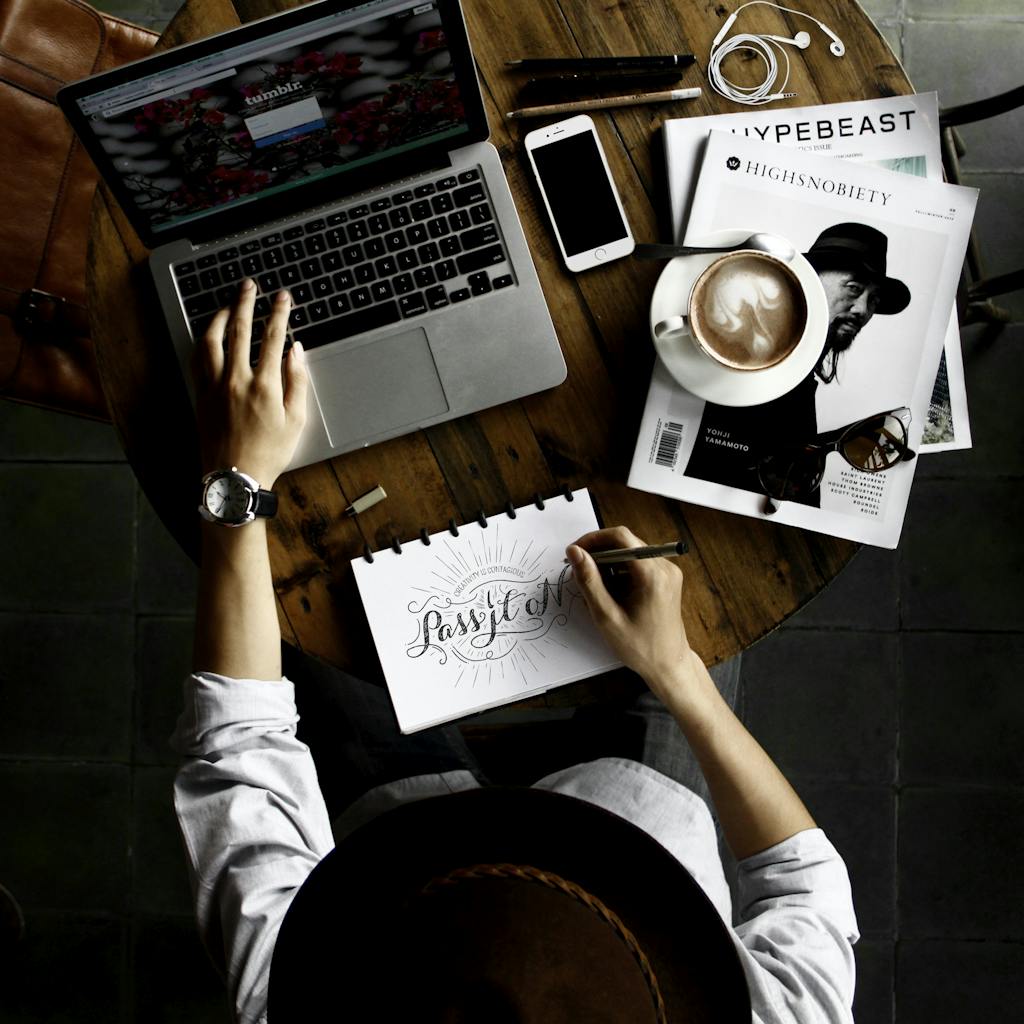 Hi there! Welcome to your Wellness journey. Top view of a creative workspace with laptop, coffee, and hand lettering for design inspiration.
